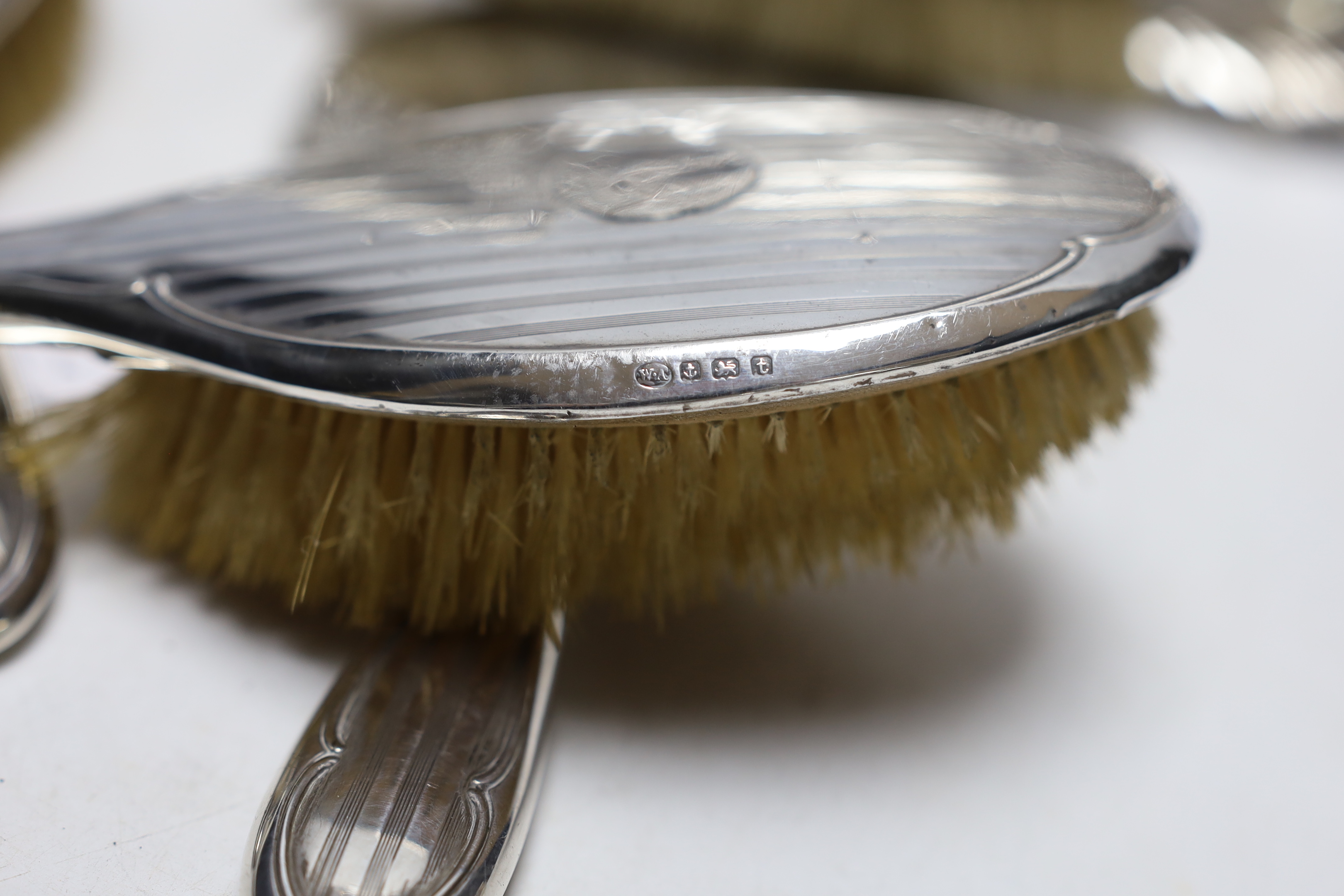 An Edwardian repousse silver dressing table tray, with Reynold's Angels decoration, Birmingham, 1904, 29.7cm, a silver dressing table mirror, two brushes, a clothes brush and two napkin rings.